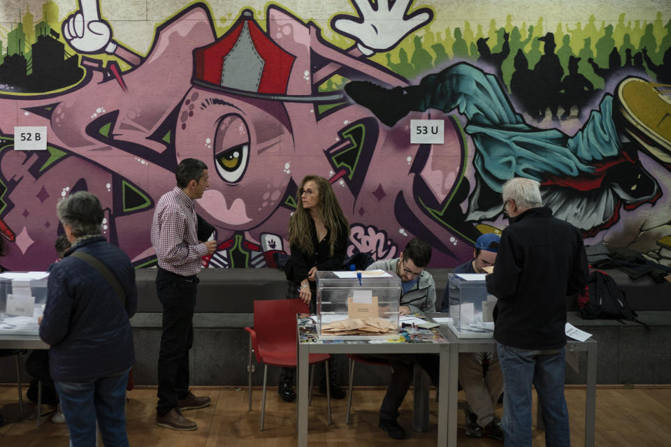 People cast their vote during Spain's general election in a polling station in Barcelona, Spain, Sunday, April 28, 2019. A divided Spain is voting in its third general election in four years, with all eyes on whether a far-right party will enter Parliament for the first time in decades and potentially help unseat the Socialist government. (AP Photo/Felipe Dana)