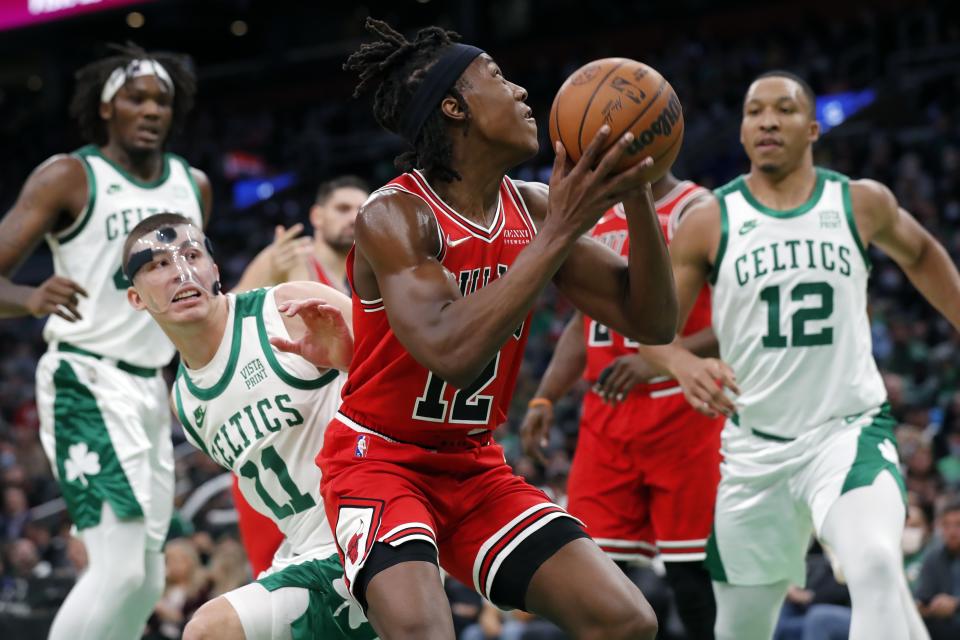 Chicago Bulls' Ayo Dosunmu, center, looks to shoot against Boston Celtics' Payton Pritchard (11) and Grant Williams, right, during the first half of an NBA basketball game, Monday, Nov. 1, 2021, in Boston. (AP Photo/Michael Dwyer)