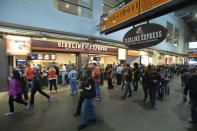 FILE - In this Oct. 12, 2014, file photo, fans walk past food concession stands prior to an NFL football game between the Cleveland Browns and the Pittsburgh Steelers, in Cleveland. The crippling coronavirus pandemic has brought the entire world — including the sports world — to a standstill, and it shows no sign of going away anytime soon. The Associated Press found during interviews with more than two dozen experts in stadiums and infrastructure that the only thing that might look the same is what happens on the field of play. The most obvious change in the short term will be the implementation of social distancing. Lines at restrooms and concessions will be limited. Congregating in the corridors will no longer be allowed. (AP Photo/David Richard, File)