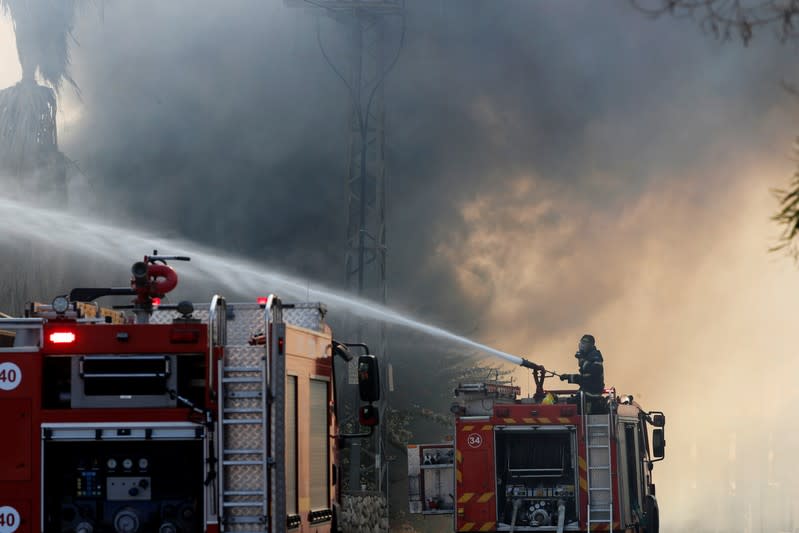 Israeli firefighters work to extinguish a fire in a factory in Sderot, southern Israel