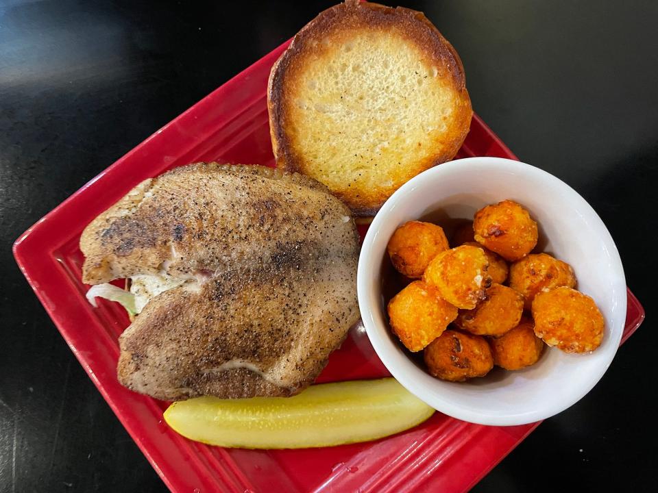 A grilled tilapia fish sandwich with sweet potato tots from Brett's Casual American restaurant in Athens, Ga. on Monday, Nov. 20, 2023. Brett's has been in business since 2007.