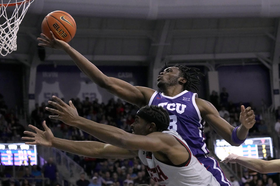 TCU center Ernest Udeh Jr. (8) reaches a rebound over Texas Tech forward Robert Jennings, bottom, in the first half of an NCAA college basketball game in Fort Worth, Texas, Tuesday, Jan. 30, 2024. (AP Photo/Tony Gutierrez)