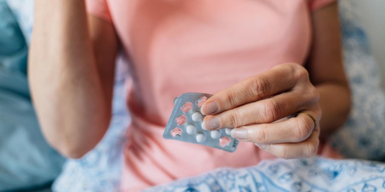 close up of woman hands with pills hormone replacement therapy