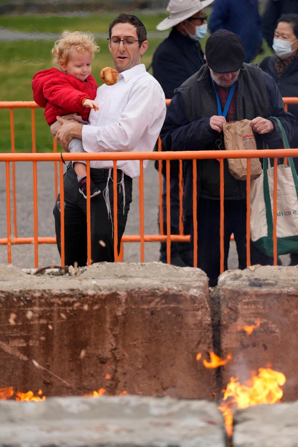Avi Schwwartz, 2, is held by his father, David Schwartz, as he throws a roll of bread into the fire. Jews came to Third Ward Park, in Passaic, Wednesday morning for the burning of the chametz. Chametz is bread or any levened food, which is forbidden for Jews to have during Passover.  Passover starts Wednesday at sundown and lasts until sundown on April 13th. Wednesday, April 5, 2023 