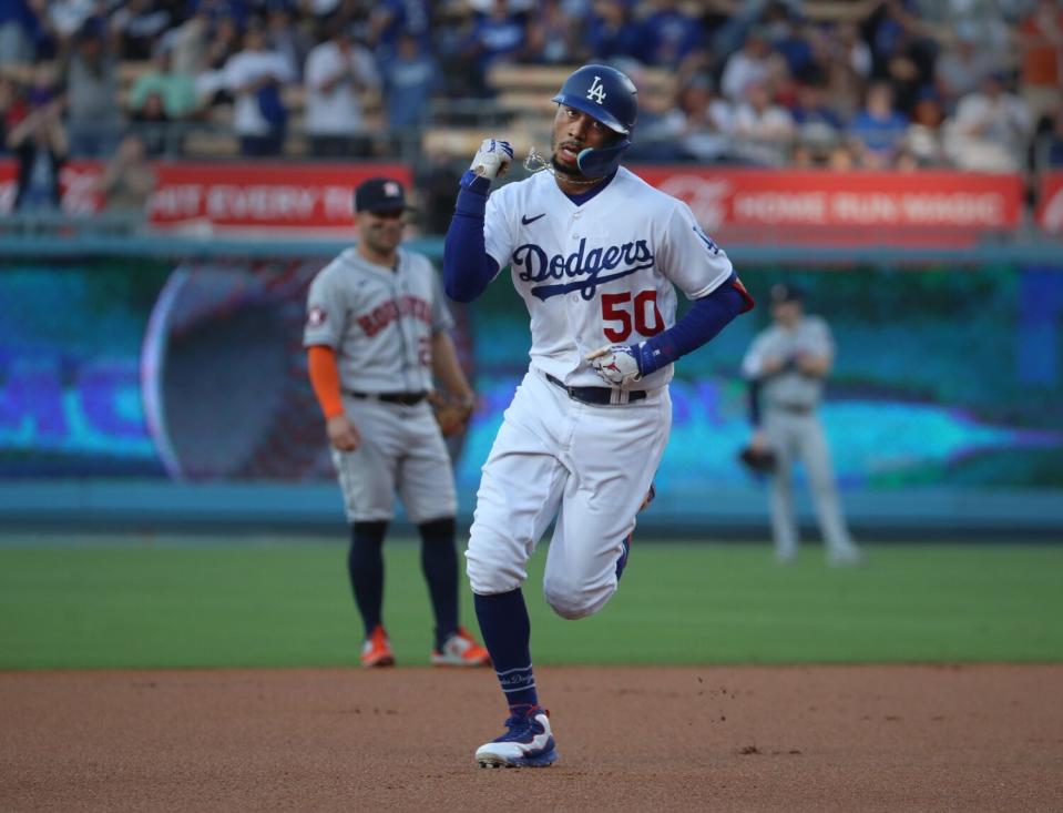 Mookie Betts pumps his fist as he rounds the bases after hitting a home run at Dodger Stadium.