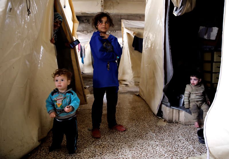 FILE PHOTO: Internally displaced Syrian children stand next to their tents in an IDP camp located in Idlib