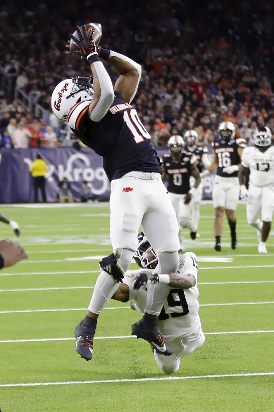 Oklahoma State wide receiver Rashod Owens (10) pulls in a reception over Texas A&M defensive back Bravion Rogers during the first half of the Texas Bowl NCAA college football game Wednesday, Dec. 27, 2023, in Houston. (AP Photo/Michael Wyke)