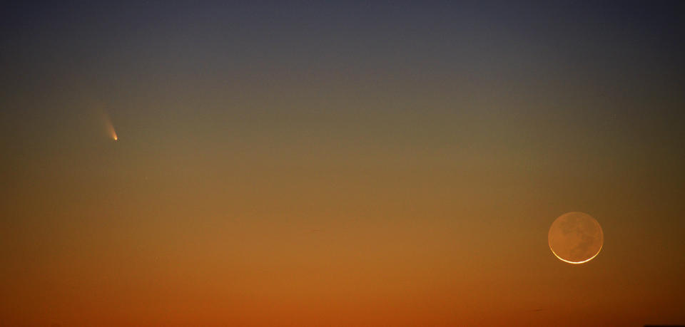 Comet PanSTARRS (left) appears to the left of a slim crescent moon in Tuesday March 12, 2013 evening's western sky. The comet rounded the sun on Sunday and is now visible low in the western evening sky. This picture was made shortly after sunset near Harrells, NC. (AP Photo/The Fayetteville Obsever- Johnny Horne)