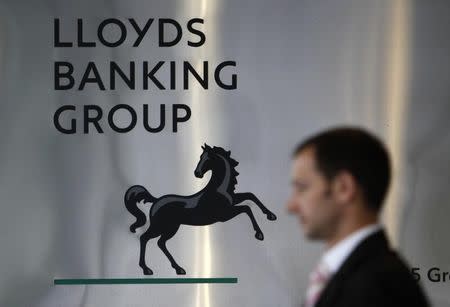 A pedestrian passes the head office of the Lloyds Banking Group in central London August 5, 2009. REUTERS/Stefan Wermuth