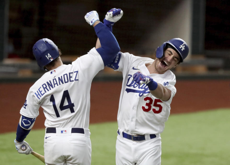 Los Angeles Dodgers' Cody Bellinger, right, celebrates his solo home run with Enrique Hernandez against Atlanta Braves relief pitcher Chris Martin during the seventh inning in Game 7 of a baseball National League Championship Series, Sunday, Oct. 18, 2020, in Arlington, Texas. (Curtis Compton/Atlanta Journal-Constitution via AP)