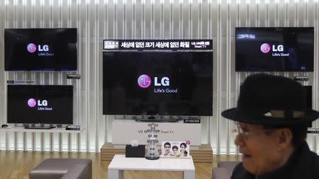 A customer walks in front of LG TV sets which are made with LG Display flat screens, at a store in Seoul January 23, 2013. REUTERS/Kim Hong-Ji