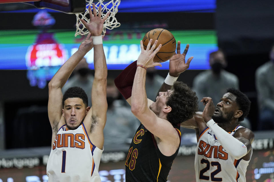 Phoenix Suns' Devin Booker (1) and Deandre Ayton (22) defend against Cleveland Cavaliers' Cedi Osman (16) in the second half of an NBA basketball game, Tuesday, May 4, 2021, in Cleveland. Phoenix won 134-118 in overtime. (AP Photo/Tony Dejak)