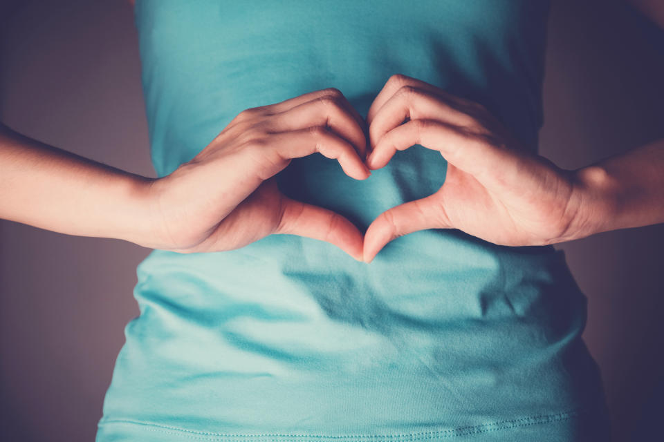 Woman hands making a heart shape on her stomach, healthy bowel degestion, probiotics  for gut health