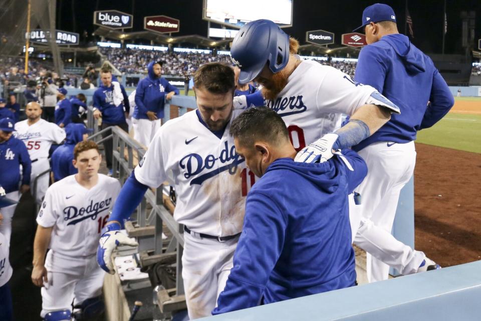 Dodgers' Justin Turner is helped into the dugout.