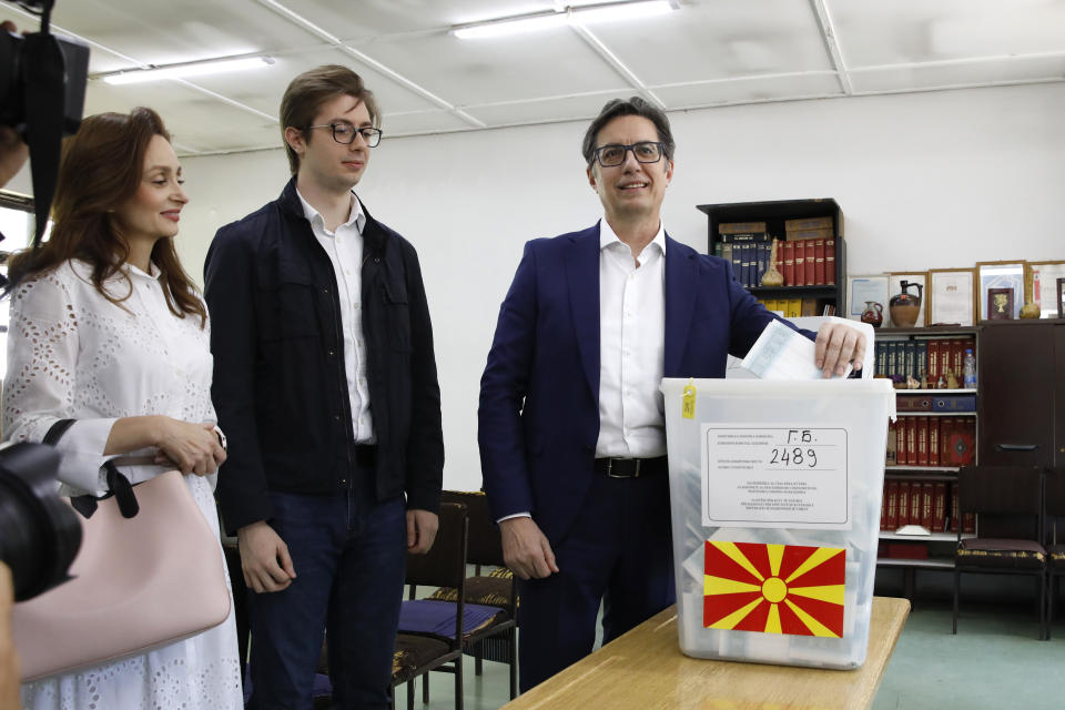 Stevo Pendarovski, incumbent President and a presidential candidate backed by the ruling social democrats (SDSM), right, casts his ballot in presence of his wife Elizabeta Gjorgievska, left and their son Ognen, center, at a polling station in Skopje, North Macedonia, on Wednesday, April 24, 2024. People are lining up at pools to cast their votes in a peaceful atmosphere, hoping that the next president will be able to bring the country into the European Union. (AP Photo/Boris Grdanoski)