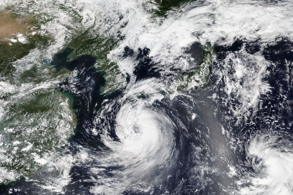 The final blow was Tropical Storm Khanun, seen here in a Nasa satellite image looming over Japan's southwestern islands (AP)