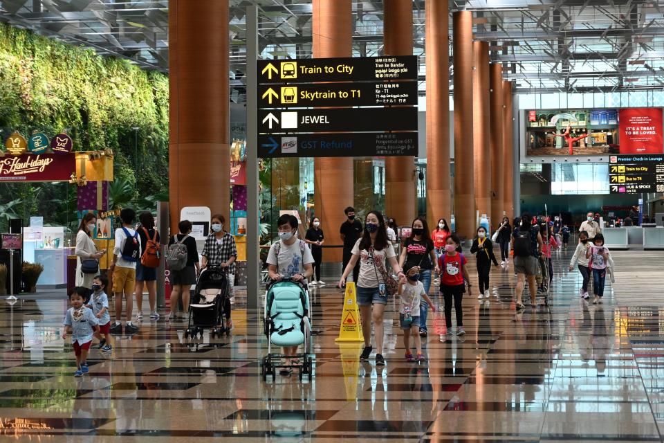 Visitors walk through a terminal of the Changi International Airport in Singapore on December 7, 2020. (Photo by Roslan RAHMAN / AFP) (Photo by ROSLAN RAHMAN/AFP via Getty Images)