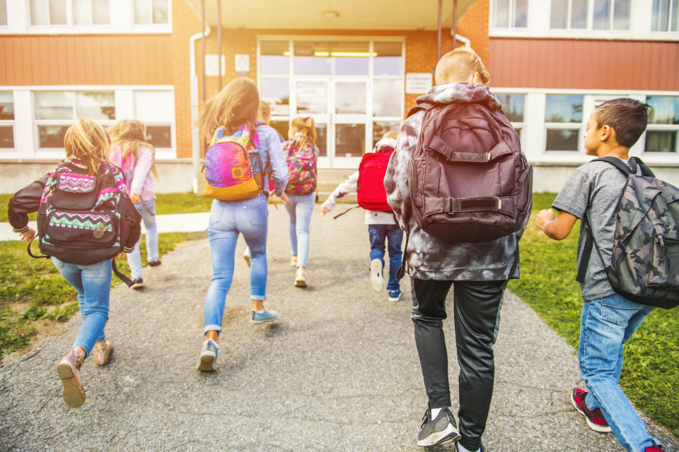 A group of kids go to the school.