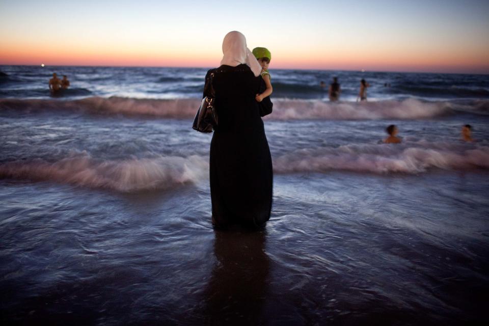 Una mujer y su bebé disfrutan del atardecer en la playa durante la festividad de Eid al-Fitr, que marca el final del mes del Ramadán. (Photo by Uriel Sinai/Getty Images)