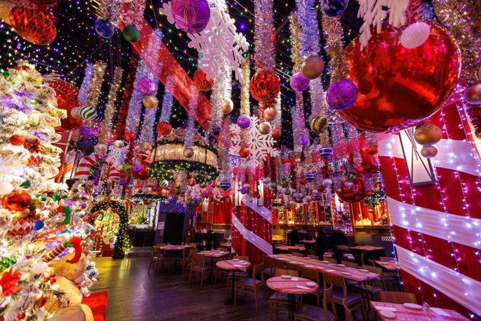 a room with tables and chairs with balloons from the ceiling