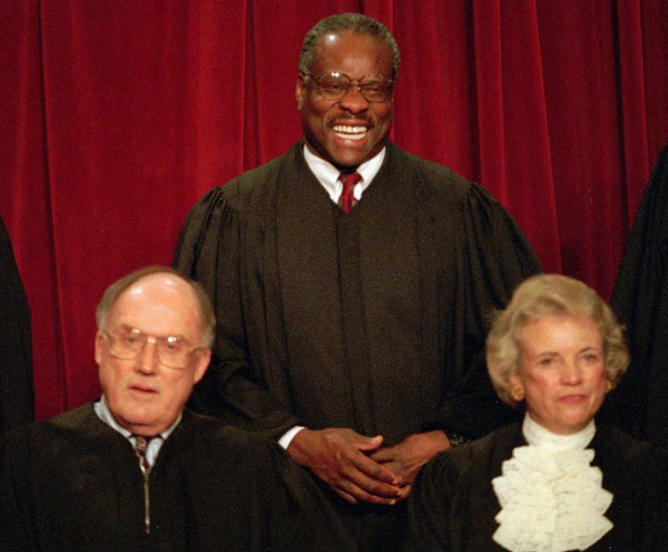 Associate Supreme Court Justice Clarence Thomas laughs while posing with other court members for a portrait on Nov. 10, 1994, at the court in Washington. Chief Justice William Rehnquist and Associate Justice Sandra Day O'Connor are in the front row.