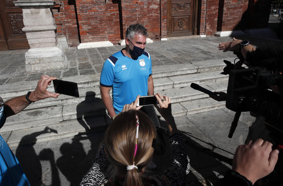 Mattia Maestri answers reporters' questions prior to the start of a 180-kilometer relay race, in Codogno, Italy, Saturday, Sept. 26, 2020. Italy’s coronavirus Patient No. 1, whose case confirmed one of the world’s deadliest outbreaks was underway, is taking part in a 180-kilometer relay race as a sign of hope for COVID victims after he himself recovered from weeks in intensive care. Mattia Maestri, a 38-year-old Unilever manager, was suited up Saturday for the start of the two-day race between Italy’s first two virus hotspots. It began in Codogno, where Maestri tested positive Feb. 21, and was ending Sunday in Vo’Euganeo, where Italy’s first official COVID death was recorded the same day. (AP Photo/Antonio Calanni)