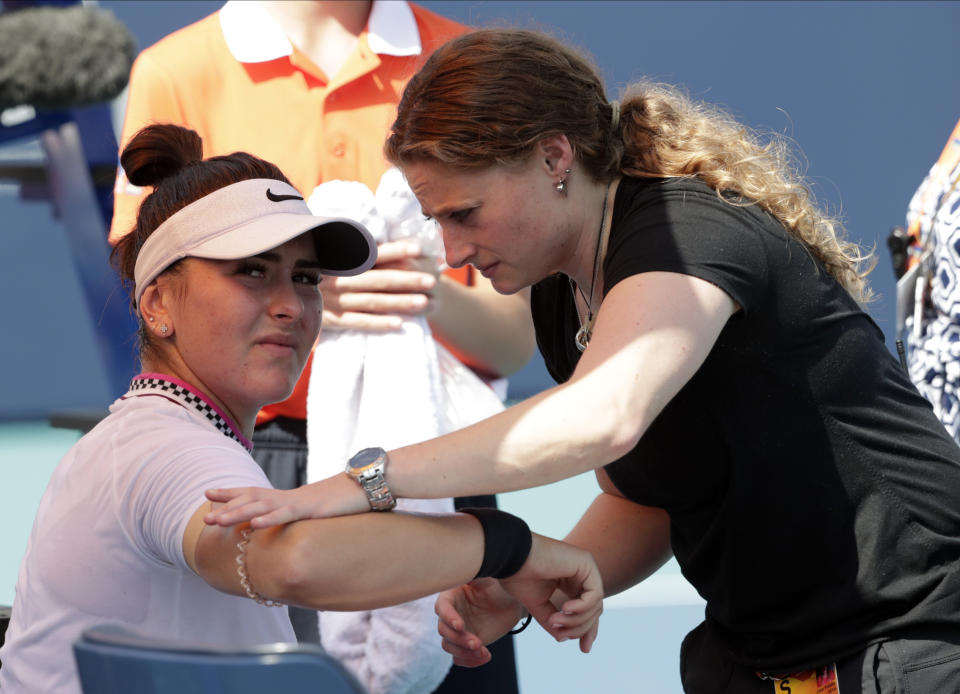 Bianca Andreescu, left, of Canada, receives medical treatment from Lisa Pataky, of the WTA, during her match against Anett Kontaveit, of Estonia, during the Miami Open tennis tournament, Monday, March 25, 2019, in Miami Gardens, Fla. Andreescu retired from the match. (AP Photo/Lynne Sladky)
