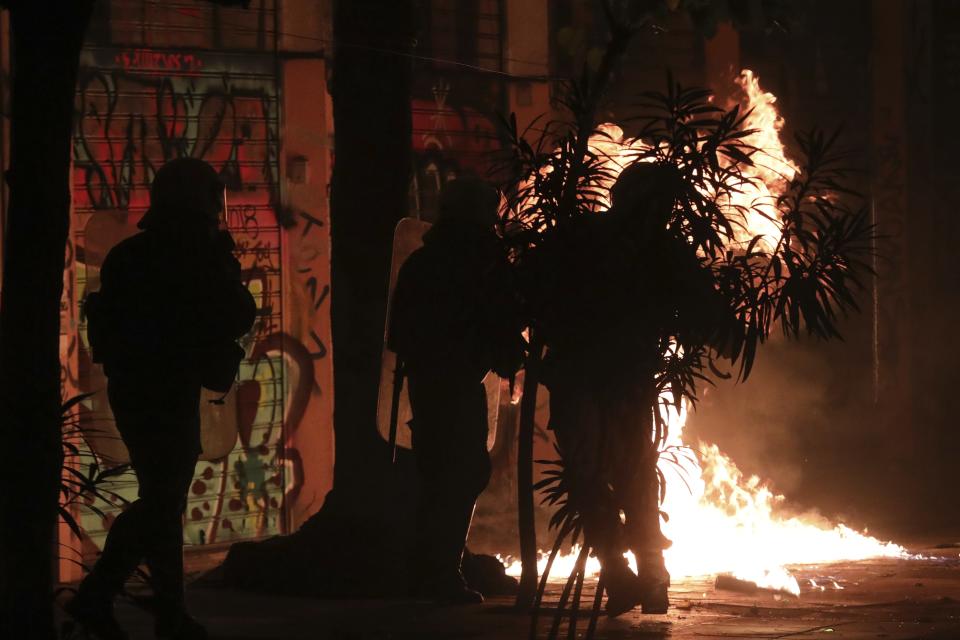 Riot policemen try to avoid petrol bombs thrown by hooded youths during clashes in the Athens neighborhood of Exarchia, a haven for extreme leftists and anarchists, Saturday, Nov. 17, 2018. Clashes have broken out between police and anarchists in central Athens on the 45th anniversary of a student uprising against Greece's then-ruling military regime. (AP Photo/Yorgos Karahalis)