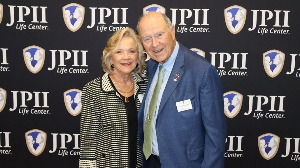 two people in front of JPII banner