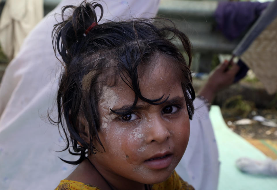 A girl poses for a photograph near her flood-hit home, in Charsadda, Pakistan, Wednesday, Aug. 31, 2022. Officials in Pakistan raised concerns Wednesday over the spread of waterborne diseases among thousands of flood victims as flood waters from powerful monsoon rains began to recede in many parts of the country. (AP Photo/Mohammad Sajjad)