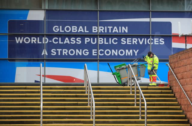 A man cleans the steps outside the Conservative Party Conference at the Manchester Central Convention Complex