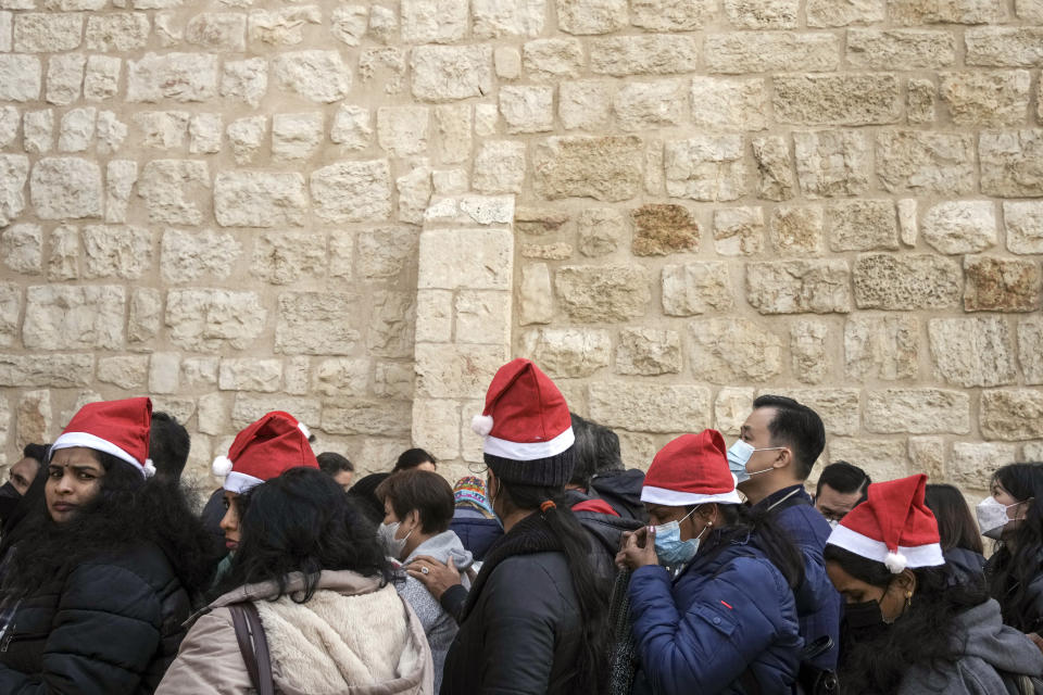 Tourists queue to enter the Church of the Nativity, traditionally believed to be the birthplace of Jesus Christ, in the West Bank town of Bethlehem, Saturday, Dec. 24, 2022. (AP Photo/Maya Alleruzzo)