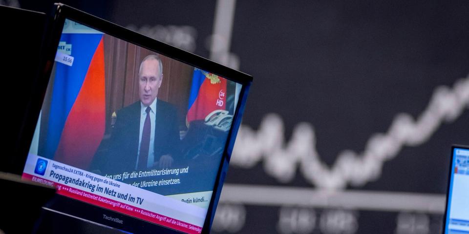 Russia's President Vladimir Putin appears on a television screen at the stock market in Frankfurt, Germany, Feb. 25, 2022. Russia is revving up its sophisticated propaganda machine as its military advances in neighboring Ukraine.