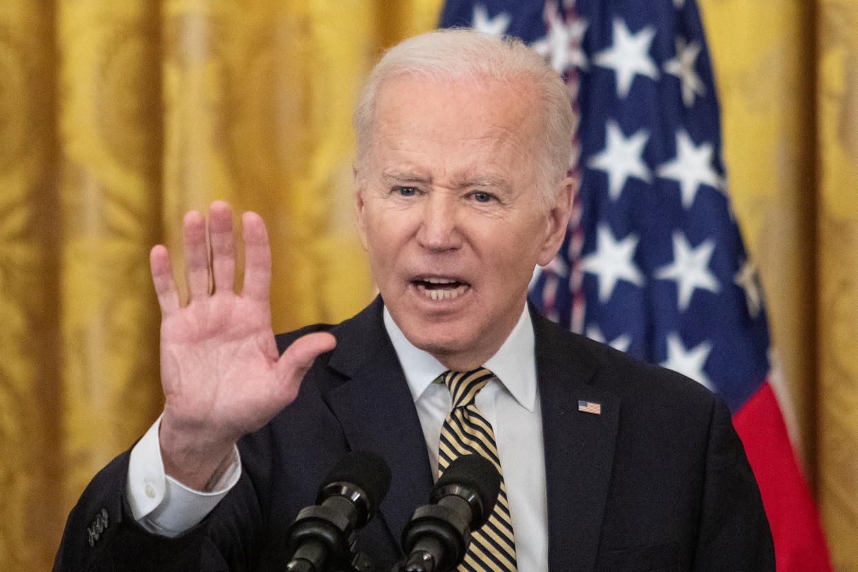 Standing in front of a U.S. flag, President Biden delivers remarks at the White House.