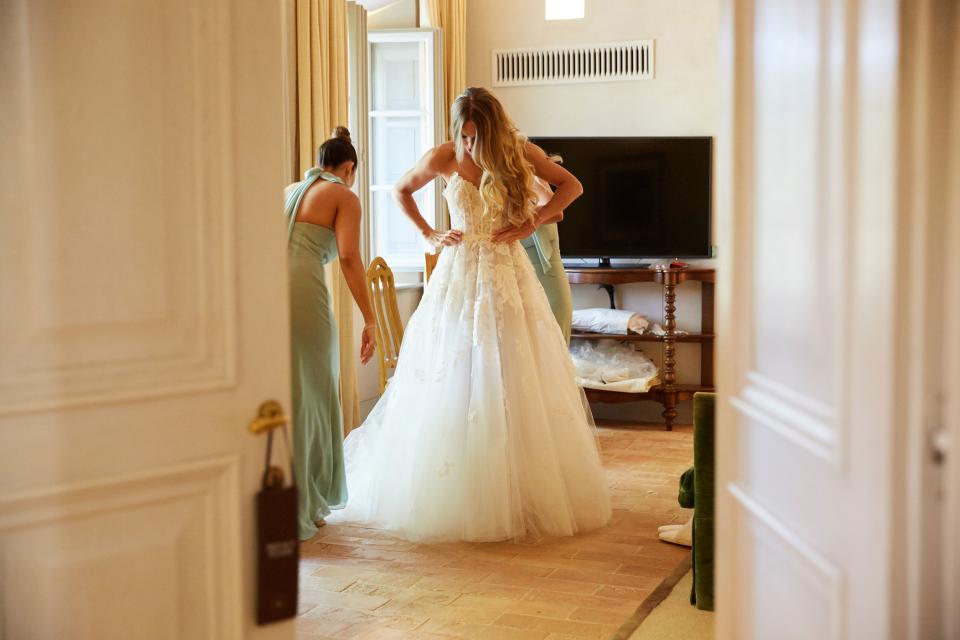 Caroline putting on her custom ordered Oscar de la Renta fern and floral lace embroidered gown.