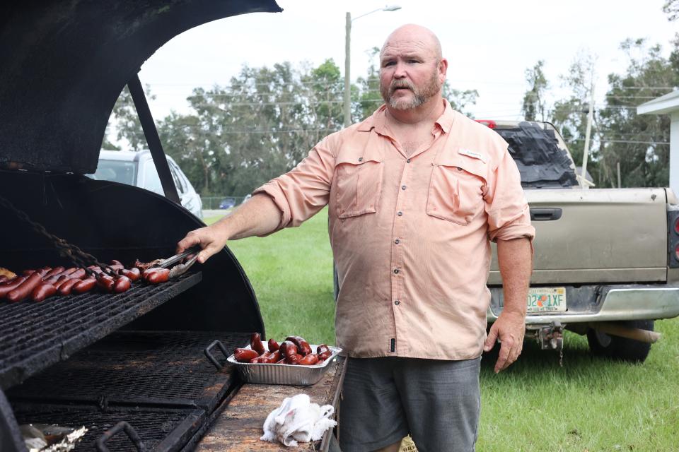 Pastor Timmy Dyke smokes sausages outside of Faith Baptist Church in Madison, Florida on Thursday, Aug. 31, 2023, the day after Hurricane Idalia hit Florida's Gulf Coast.