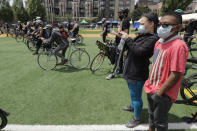 Xavier Smalls, 15, right, stands with his mother, Ana Smalls, after they rode their bikes to a rally in Cal Anderson Park in the "Ride for Justice," Thursday, June 11, 2020, Seattle. People rode to the park and then took part in a rally to protest against police brutality and racial inequality. (AP Photo/Ted S. Warren)