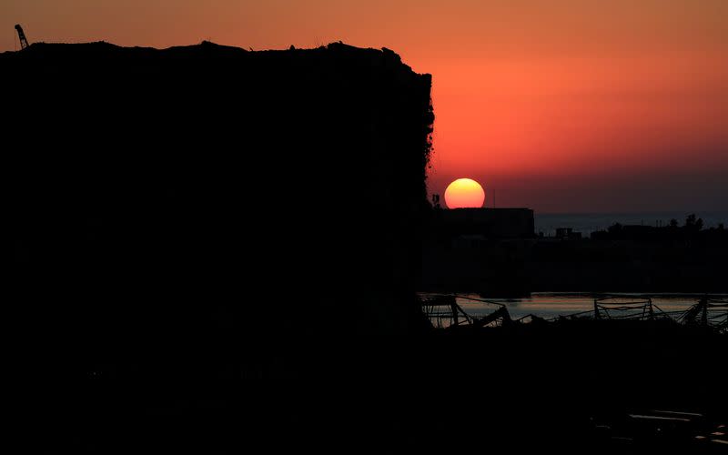 A view shows the damaged port area in the aftermath of a massive explosion at sunset in Beirut