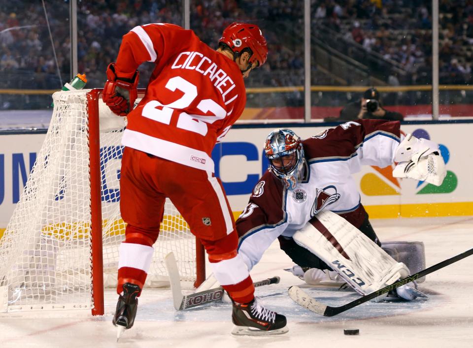 Red Wings right wing Dino Ciccarelli, left, takes a shot against Avalanche goalie Patrick Roy during the second period of the Wings' 5-2 loss in the alumni game Friday at Coors Field.