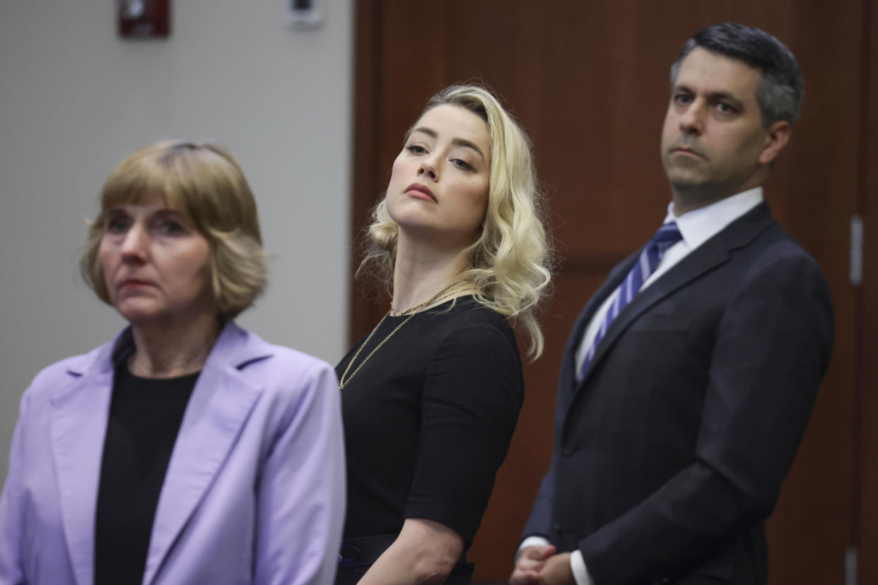 Actor Amber Heard and her attorneys Elaine Bredehoft and Benjamin Rottenborn looks over to the jury just before the verdict was read at the Fairfax County Circuit Courthouse in Fairfax, Va, Wednesday, June 1, 2022. The jury awarded Johnny Depp more than $10 million in his libel lawsuit against ex-wife Amber Heard. It vindicates his stance that Heard fabricated claims that she was abused by Depp before and during their brief marriage. But the jury also found in favor of Heard, who said she was defamed by a lawyer for Depp.(Evelyn Hockstein/Pool via AP)