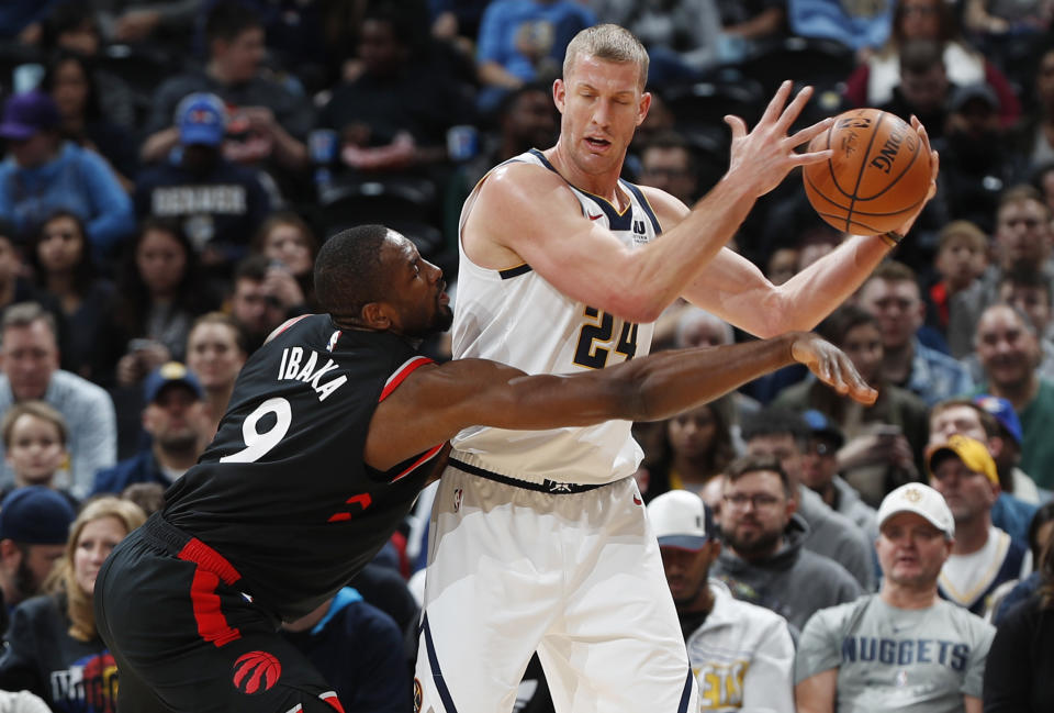 Serge Ibala, alero de los Raptors de Toronto, trata de robarle el balón a Mason Plumlee, de los Nuggets de Denver, en el encuentro del domingo 16 de diciembre de 2018 (AP Foto/David Zalubowski)