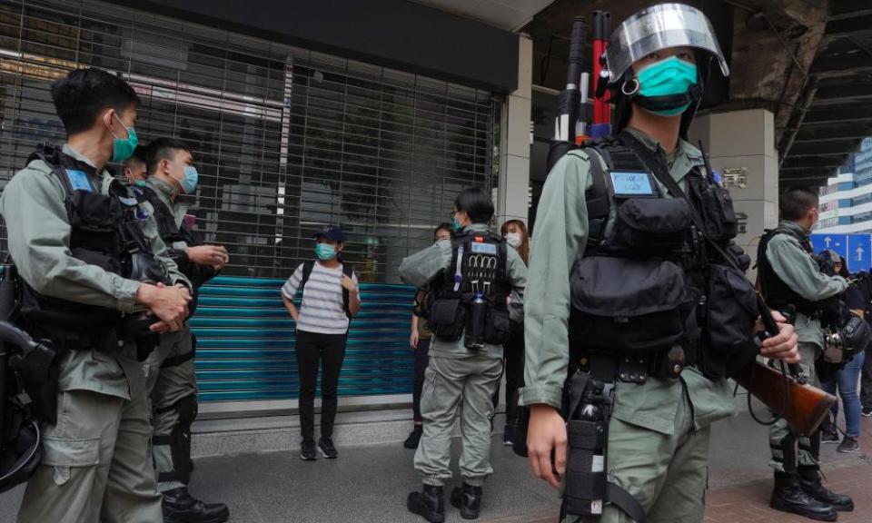 Riot police check a pedestrian in Causeway Bay, Hong Kong