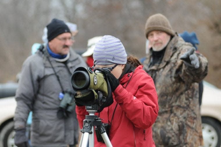 Participants at Marsh Madness in 2011 watch whooping cranes that were stopping at Goose Pond Fish and Wildlife Area while migrating north.