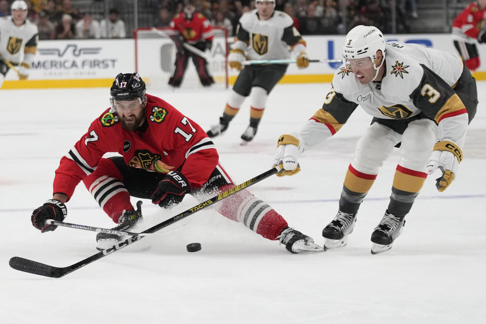 Chicago Blackhawks left wing Nick Foligno (17) and Vegas Golden Knights defenseman Brayden McNabb (3) battle for the puck during the first period of an NHL hockey game Friday, Oct. 27, 2023, in Las Vegas. (AP Photo/John Locher)