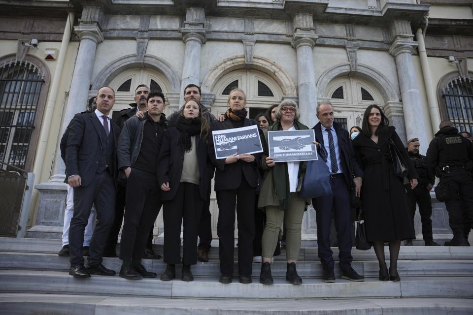 Protesters, laywyers and aid workers pose for the media outside a court in Mytilene, on the northeastern Aegean island of Lesbos, Greece, Friday, Jan. 13, 2023. The trial of 24 Greek and foreign aid workers and volunteers who participated in migrant rescue operations has drawn widespread criticism from international human rights groups. (AP Photo/Panagiotis Balaskas)