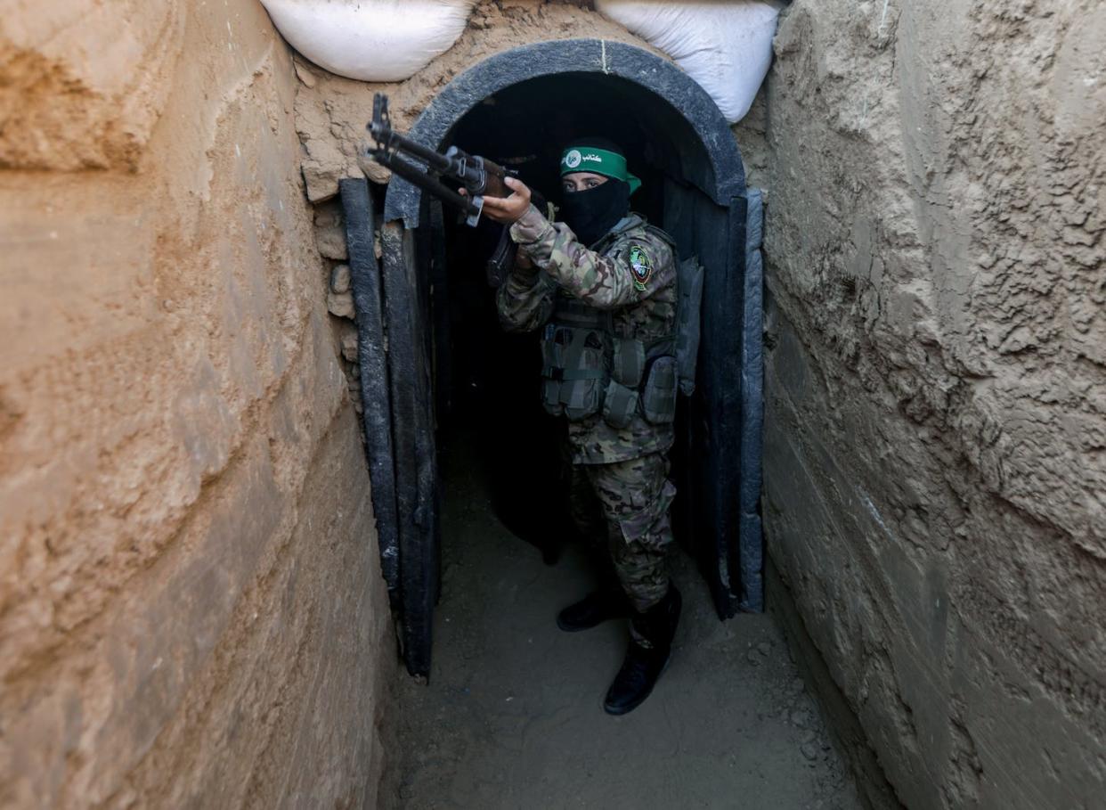 A Hamas fighter steps out of a tunnel during a 2014 public demonstration of the group's military abilities. <a href="https://www.gettyimages.com/detail/news-photo/fighter-from-izz-al-din-al-qassam-stands-in-front-of-a-news-photo/1546737195" rel="nofollow noopener" target="_blank" data-ylk="slk:Yousef Masoud/SOPA Images/LightRocket via Getty Images;elm:context_link;itc:0;sec:content-canvas" class="link ">Yousef Masoud/SOPA Images/LightRocket via Getty Images</a>