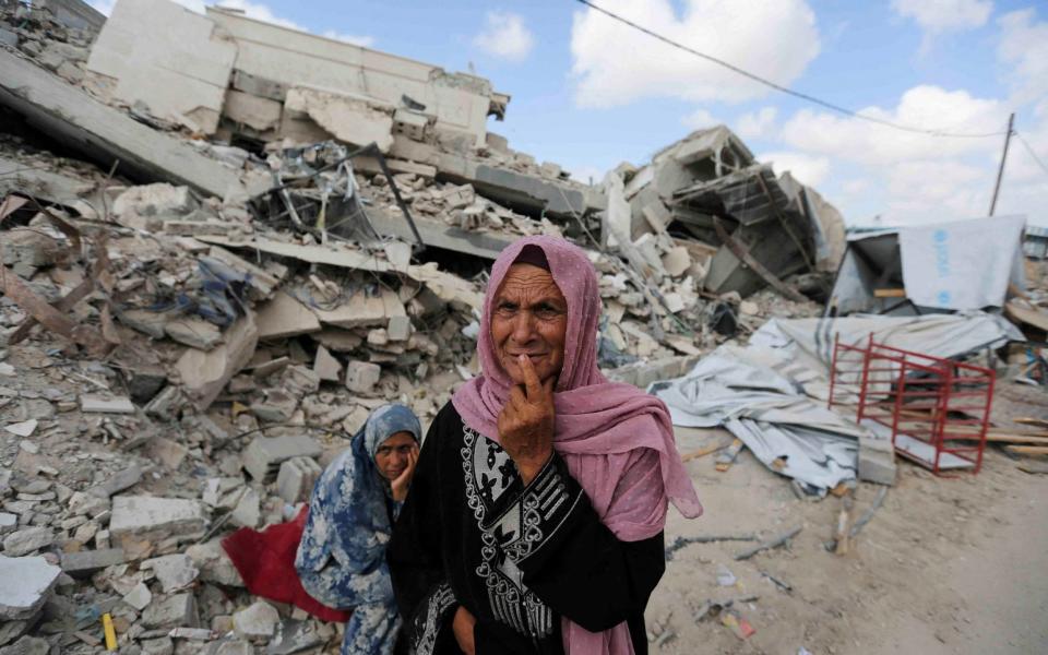 A Palestinian woman cries as she returns to the rubble of her home