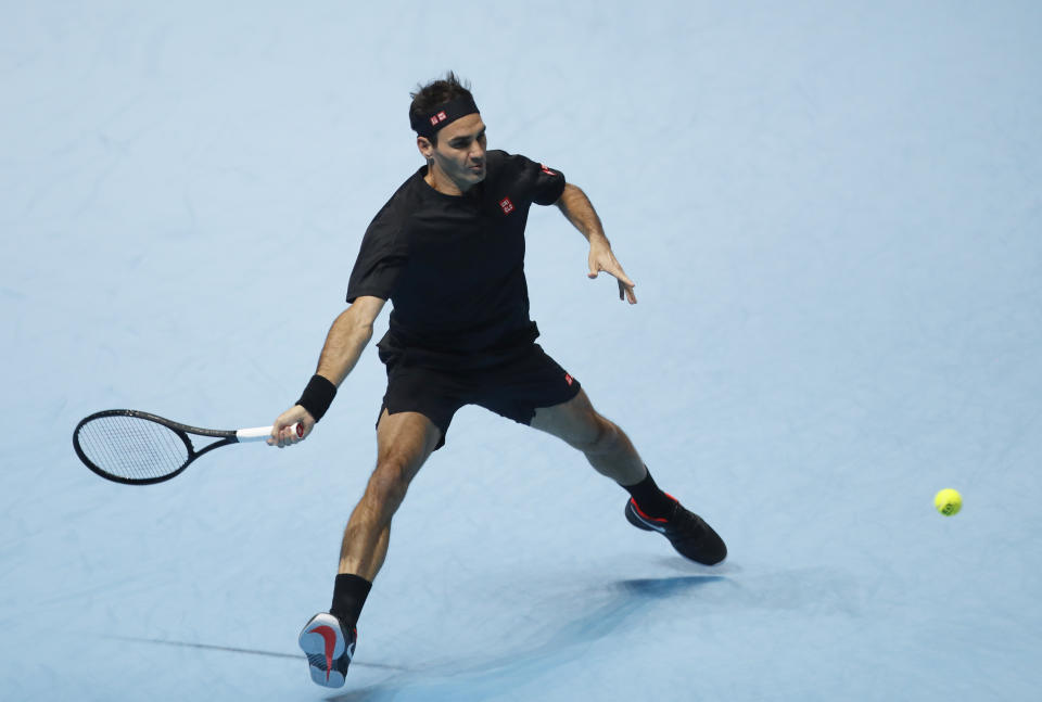 El suizo Roger Federer devuelve ante el italiano Matteo Berrettini durante su partido por la Copa Masters de la ATP en Londres, el martes 12 de noviembre de 2019. (AP Foto/Alastair Grant)