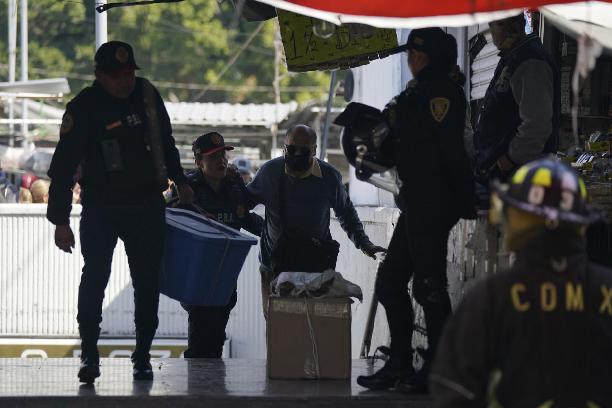 A subway passenger is escorted up a flight of stairs from the Raza station where two subway trains collided, in Mexico City, Saturday, Jan. 7, 2023. Authorities announced at least one person was killed and dozens were injured. (AP Photo/Fernando Llano)