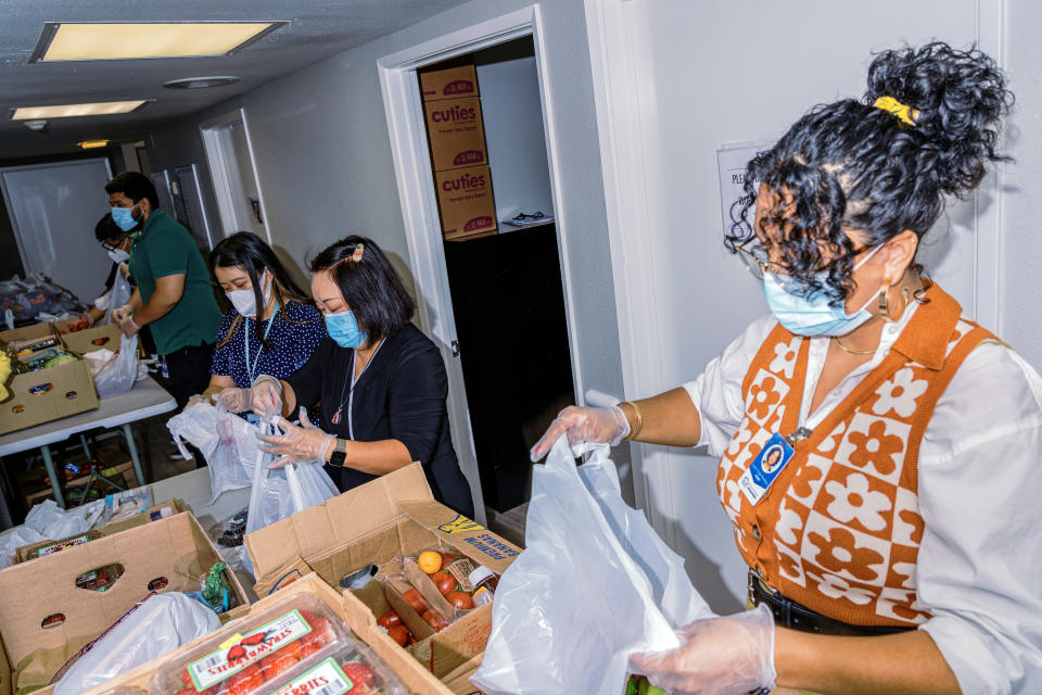 Miembros del personal del Centro La Familia, un centro vecinal de Fresno, California, clasifican los alimentos donados por Vue Vang para distribuirlos entre las personas que los necesitan el 9 de agosto de 2022. (Andri Tambunan/The New York Times).